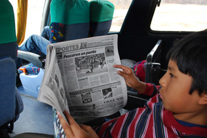 スペイン語の新聞を読むペルーの少年